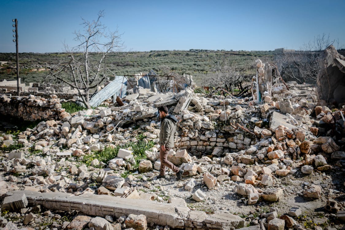 A man near destroyed buildings in Syria.